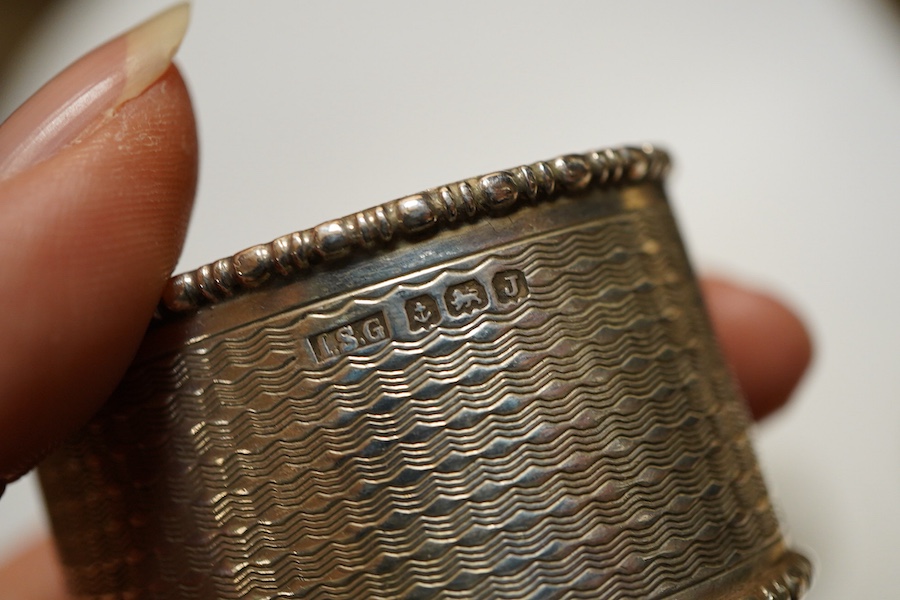 Assorted silver napkin rings, to include a George V engine turned oval pair, Birmingham, 1933, I S Greenberg & Co, initialled, four others and a pepper pot, weight approx. 6.34ozt